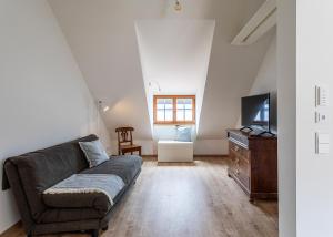 a living room with a couch and a tv at Ferienwohnungen SEEELF - Luv Stay in Überlingen