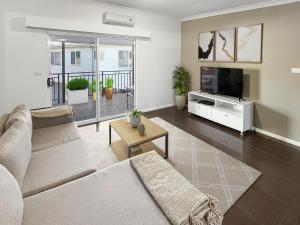 a living room with a couch and a flat screen tv at H2O Holiday Apartments - Unit 10 in North Haven