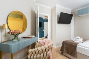 a bedroom with a blue desk with a mirror and a bed at Rooftop Wawel view with jacuzzi l luxury apartment in Kraków +34 photos