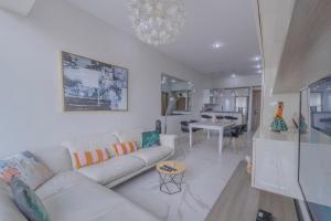 sala de estar con sofá blanco y comedor en Apt with Reforma View Pool and Jacuzzi, en Ciudad de México