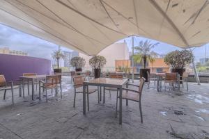 un grupo de mesas y sillas bajo una tienda en Apt with Reforma View Pool and Jacuzzi, en Ciudad de México