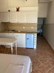 a kitchen with white cabinets and a blue refrigerator at Harmony Seaside Pelion in Platanias