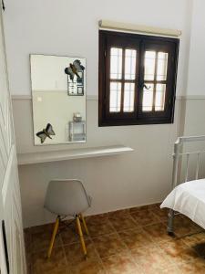 a room with a chair and a window and a bed at Harmony Seaside Pelion in Platanias