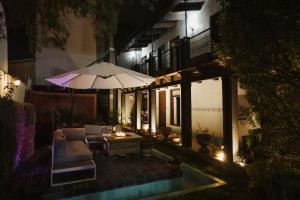 a patio with an umbrella next to a pool at night at Yox Hotel Boutique in San Crist&oacute;bal de Las Casas