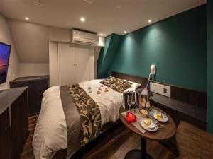 Hotel GEM2 - Adult Only في سيندايْ: غرفة نوم صغيرة بها سرير وطاولة