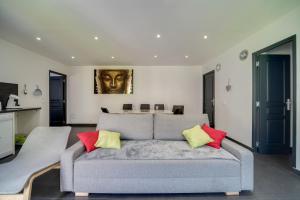 a living room with a gray couch with colorful pillows at La Sérénade Numéro 2 in Montreuil