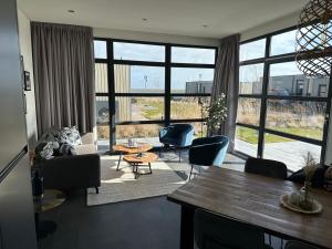 a living room with a couch and chairs and a table at Enkhuizer Strand Chalet Windrose mit Zaun Haus Nr 225 in Enkhuizen +14 photos