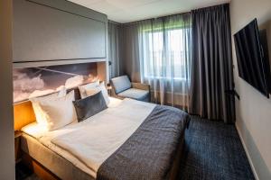 a hotel room with a bed and a chair at Airport Hotel, Billund in Billund