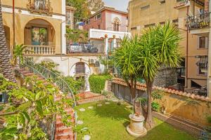 an apartment with a courtyard with a palm tree at Casa Fabrizio in Taormina +14 photos