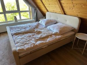 een ongemaakt bed in een kamer met een raam bij Altes Forsthaus Fischbach in Sankt Andreasberg