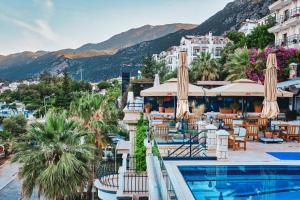 a view of a hotel with a pool and tables and umbrellas at Aqua Princess Hotel in Kaş