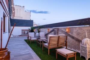 un gruppo di sedie e tavoli su un patio di Espectacular Casa de lujo con chimenea, barbacoa, jacuzzi y vistas panorámicas a toda Granada ad Alfacar Altre 86 foto