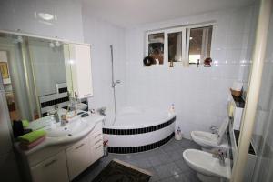 ein Badezimmer mit einer Badewanne, 2 Waschbecken und einem WC in der Unterkunft Apartman Mak in Bihać