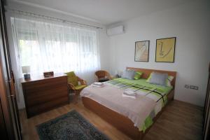 ein Schlafzimmer mit Bett, Schreibtisch und Fenster in der Unterkunft Apartman Mak in Bihać