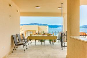 a dining room with a table and chairs on a balcony at Villa ARIJANA 2 in Slatine
