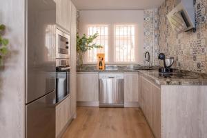 una cucina con frigorifero e armadietti in acciaio inossidabile di Espectacular Casa de lujo con chimenea, barbacoa, jacuzzi y vistas panorámicas a toda Granada ad Alfacar