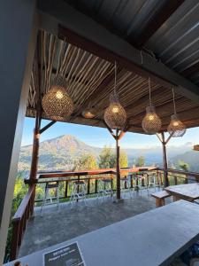 a patio with tables and chairs and a view of a mountain at Pinggan luxury camp in Baturaja