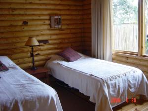 a bedroom with two beds in a log cabin at Log Villa in Cape Town