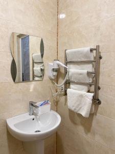 a bathroom with a sink and a mirror and towels at Hotel Chicago in Uman