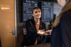 a woman standing at a counter in a coffee shop at Airport Hotel, Billund in Billund