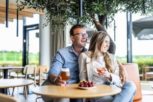 a man and woman sitting at a table in a restaurant at Airport Hotel, Billund in Billund