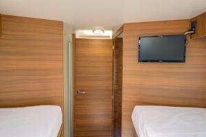 a room with two beds and a flat screen tv at Autocaravana Baron 573 in Cerdanyola del Valles