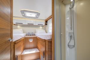 a small room with two beds and a shower at Autocaravana Baron 573 in Cerdanyola del Valles +5 photos