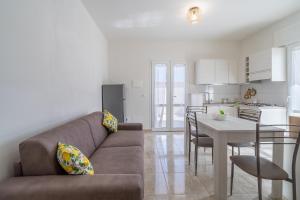 a living room and kitchen with a couch and a table at Littiricci in Marzamemi