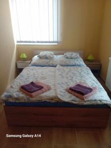 a bed in a bedroom with towels on it at Kötél utcai vendégház in Balatonkeresztúr