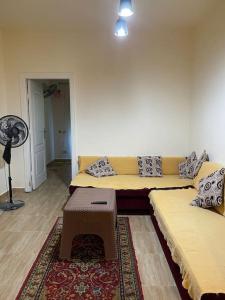 ein Wohnzimmer mit einem Sofa und einem Ventilator in der Unterkunft Tahiti resort north coast in Dawwār ‘Abd Allāh + 3 Fotos