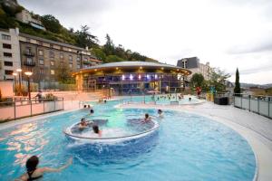 a group of people swimming in a swimming pool at Appartement Royat bourg in Royat