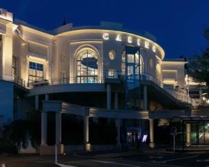 a building with a sign that reads casino at night at Appartement Royat bourg in Royat