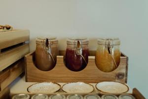 three jars of honey and plates in a drawer at Opal Paros in Naousa