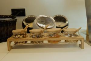 a shelf with several glass bowls and wooden spoons at Opal Paros in Naousa