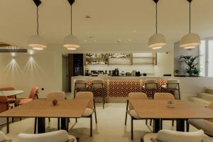 a restaurant with tables and chairs and a bar at Opal Paros in Naousa