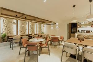 a restaurant with tables and chairs and a bar at Opal Paros in Naousa