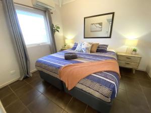 a bedroom with a large bed with a window at Osprey Holiday Village Unit 113 2 Bedroom in Exmouth +9 photos