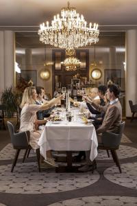 a group of people sitting around a table in a restaurant at Hotel la Palma au Lac in Locarno