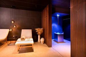 a room with a white chair and a blue room at Hotel la Palma au Lac in Locarno