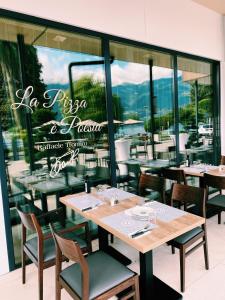 a restaurant with tables and chairs in front of a window at Hotel la Palma au Lac in Locarno