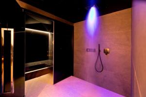 a bathroom with a shower with a blue light at Hotel la Palma au Lac in Locarno