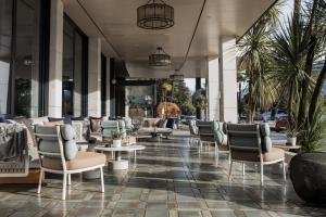 a lobby with chairs and tables and palm trees at Hotel la Palma au Lac in Locarno