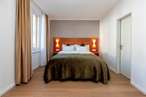 a bedroom with a large bed with two lamps at Hotel la Palma au Lac in Locarno