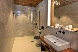a bathroom with a sink and a toilet and a mirror at Hotel la Palma au Lac in Locarno
