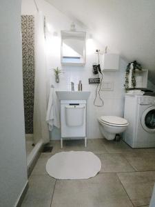 a white bathroom with a sink and a toilet at Apartment Astina in Koper