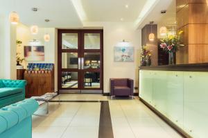 a lobby with a waiting room with a blue couch at Park Grand Hyde Park in London
