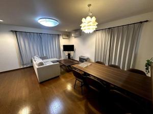 a living room with a table and a couch at 函館民泊谷地頭 in Hakodate