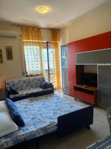 una camera da letto con un letto, un divano e una televisione di Casa Talassa a Pescara