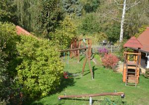 a playground in a yard with a swing at Ferienwohnung Adriaurlaub Sachsen in Großdubrau +1 photo