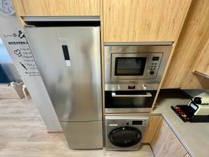a stainless steel refrigerator and microwave in a kitchen at Beach Apartment, Torre Benagalbón in Torre de Benagalbón